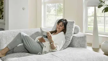 Frau ließt Zeitschrift auf bequemer Couch